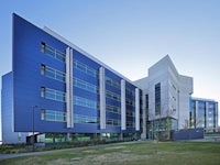 a blue building with a grassy area in front of it