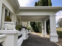 the entrance to a house with white pillars and potted plants